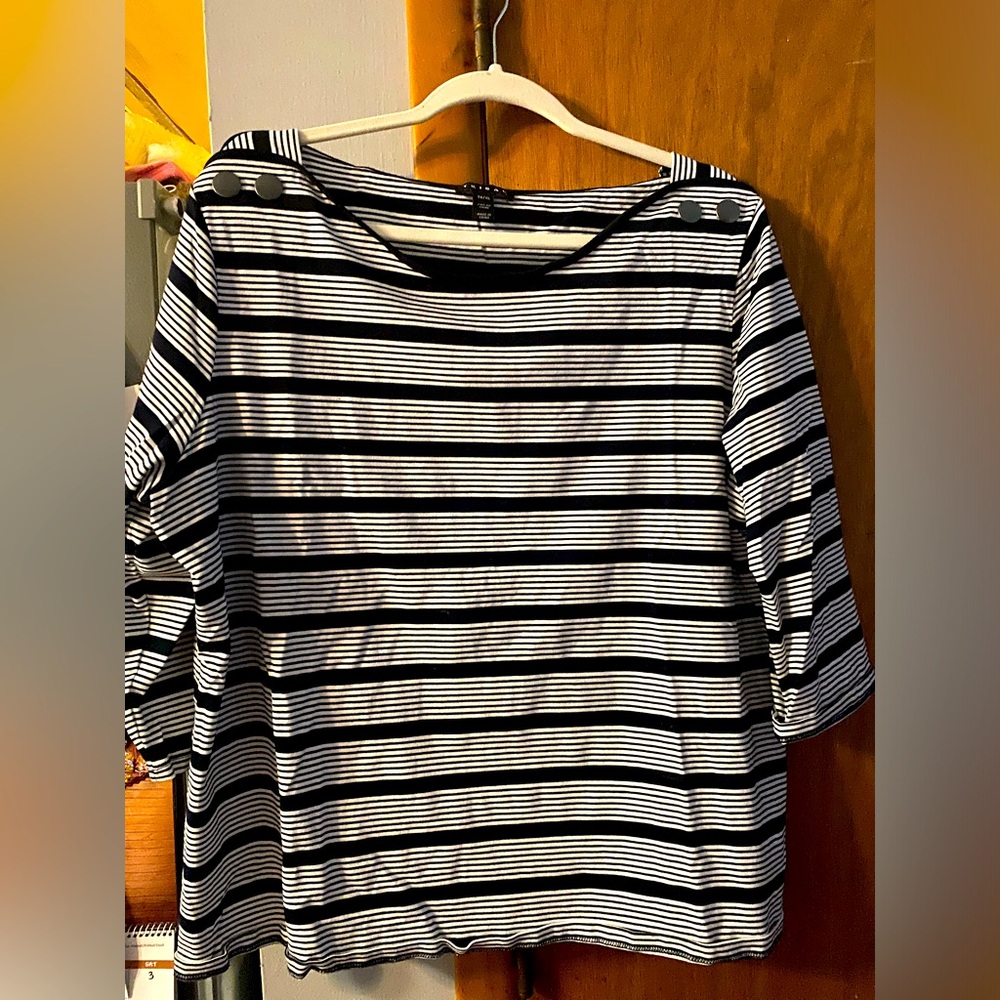 3/4 quarter sleeves, black and white strip. Two button accent on each shoulder.
